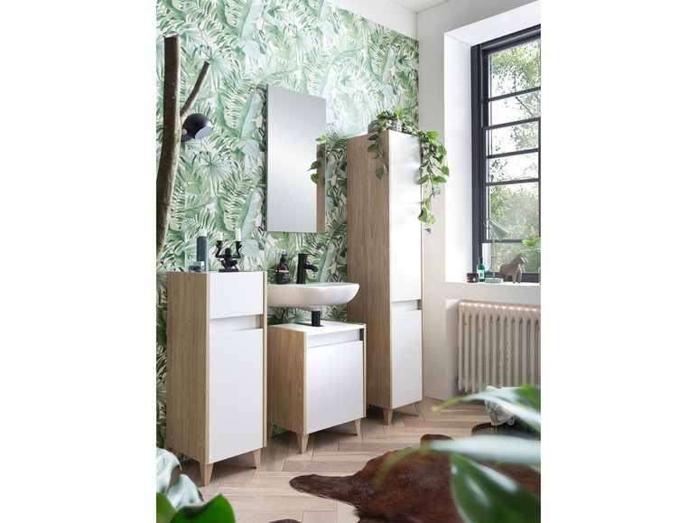 Badezimmer mit weißer Waschbecken, Spiegel und Badezimmermöbeln aus Holz.