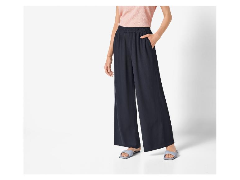 Schwarze weite Hose und flache Sandalen: eleganter, lässiger Look.