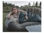 Eine Frau liegt auf einer aufblasbaren Couch mit einem Easy Camp Schlafsack.