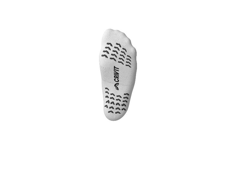 Weißer Antirutschsocken mit schwarzer gemusterter Sohle.