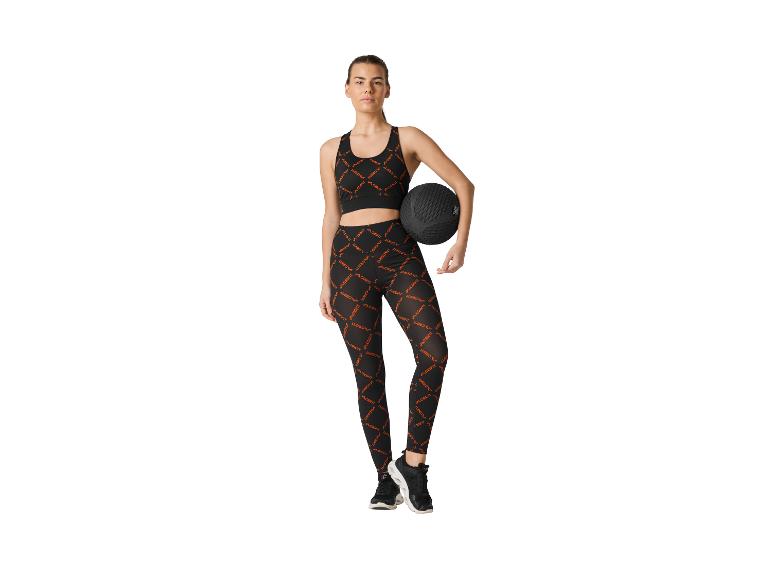 Frau in schwarzem CRIVIT Sport-BH und Leggings mit Medizinball.