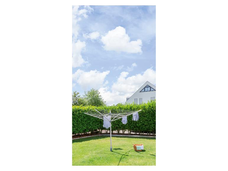 Ein Wäscheständer mit Wäsche, die in einem sonnigen Garten trocknet.