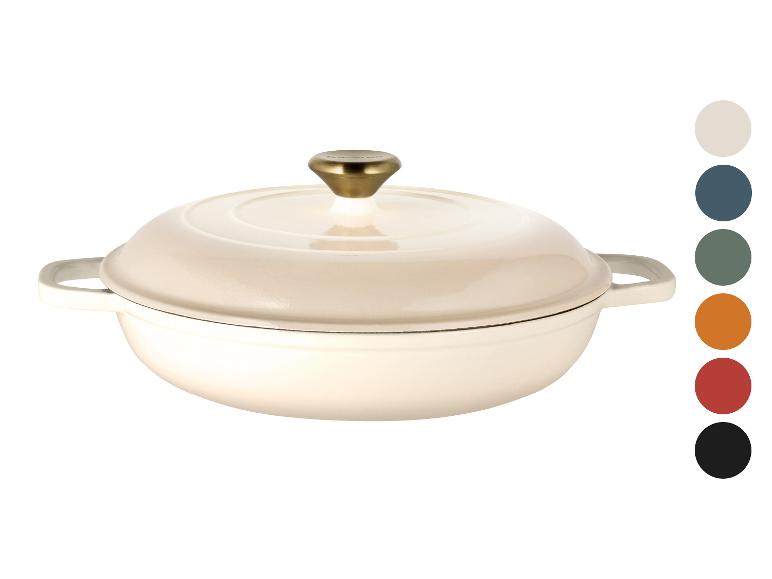 Cremefarbener Gusseisentopf mit goldenem Knauf, abgebildet mit Farbmustern.