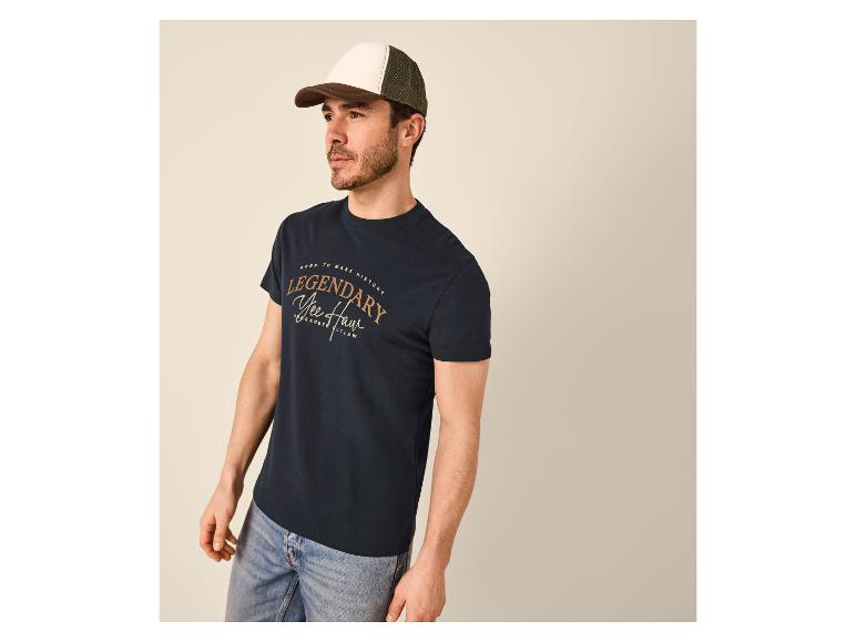 Mann in einem dunkelblauen T-Shirt mit „Legendary Yee Haw“-Aufdruck und zweifarbiger Kappe.