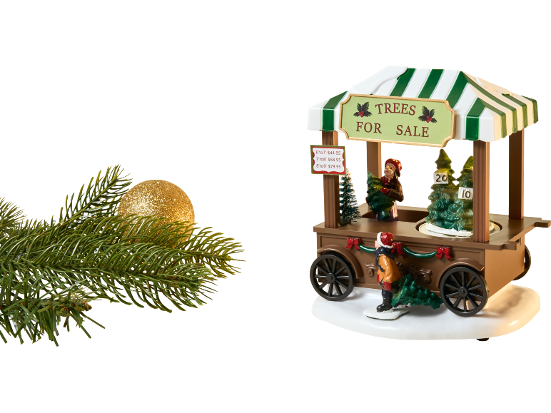 Weihnachtsbaumverkaufsstand mit Miniaturfiguren, Bäumen und Preisliste, neben einem glitzernden Goldornament und Tannenzweig.