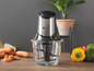 Ein silberfarbener Moulinex-Food-Processor mit Glasbehälter und Gemüse.
