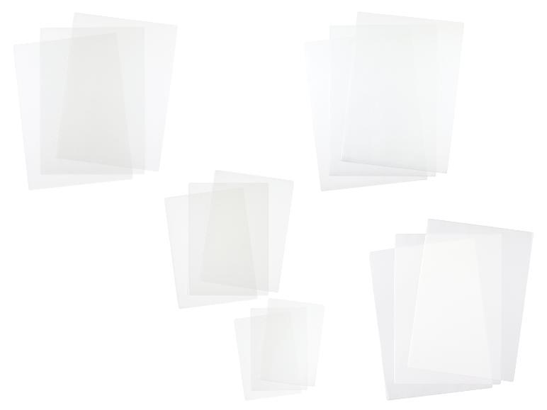 Mehrere Stapel transparenter Plastikfolien oder Dokumentenhüllen auf weißem Hintergrund.