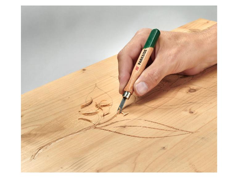 Eine Hand verwendet ein Parkside-Stechbeitel, um ein Blatt in Holz zu schnitzen.