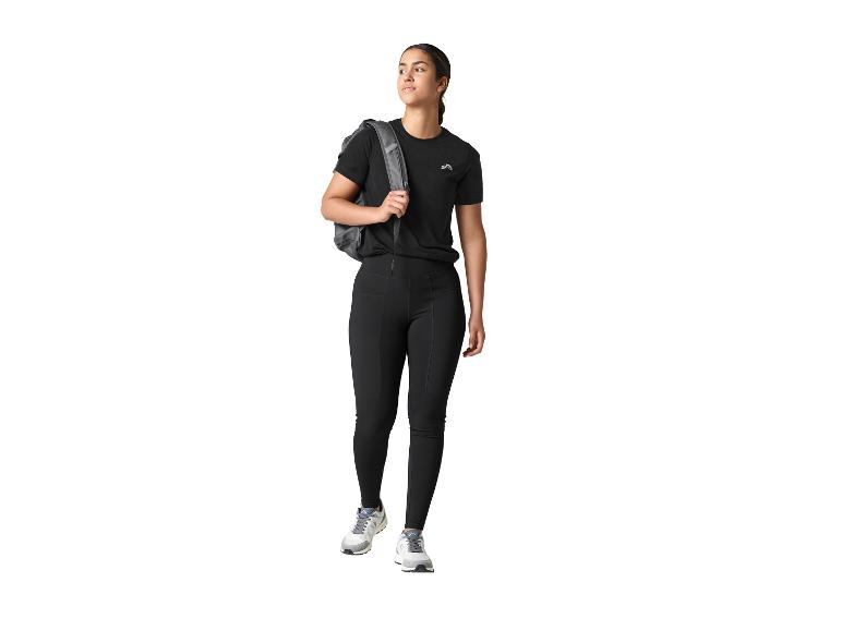 Frau in schwarzen CRIVIT Funktionstights und schwarzem T-Shirt mit Rucksack, blickt zur Seite.
