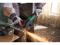 Handwerker schneidet ein in einen Schraubstock eingespanntes Metallrohr mit einem Winkelschleifer.