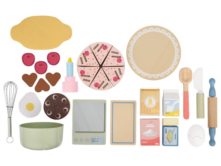 Ein Backspielset mit Kuchen, Himbeeren, Backzutaten und Küchenutensilien.