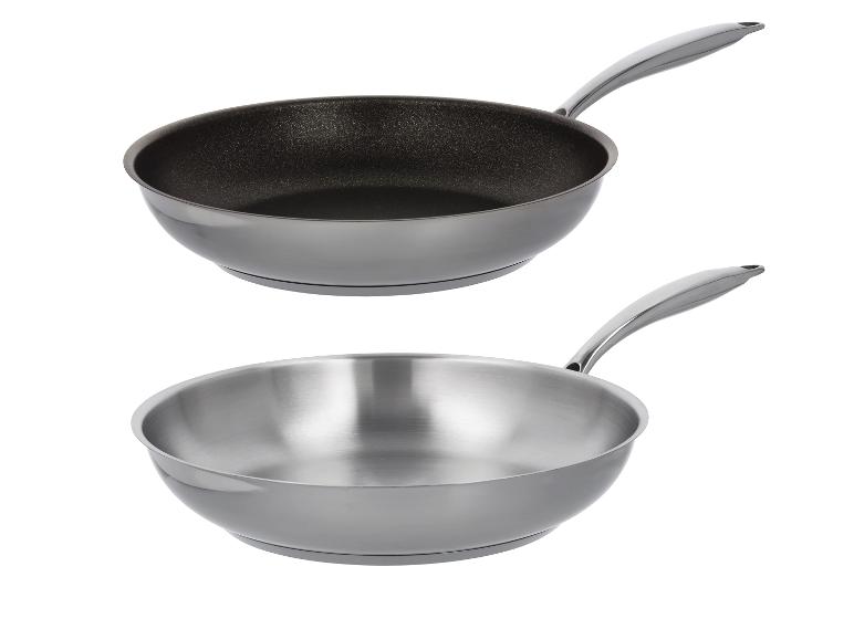 Zwei Bratpfannen, eine mit Antihaftbeschichtung und eine aus Edelstahl.