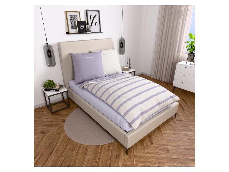 Schlafzimmer mit beigem Bett, Tom Tailor Bettwäsche und moderner Einrichtung.