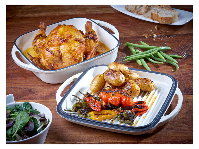 Gebratener Hähnchen, Kartoffeln und Paprika in einer weißen Auflaufform.