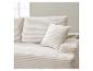 Cremefarbenes Cord-Sofa mit Kissen in einem hellen Interieur.