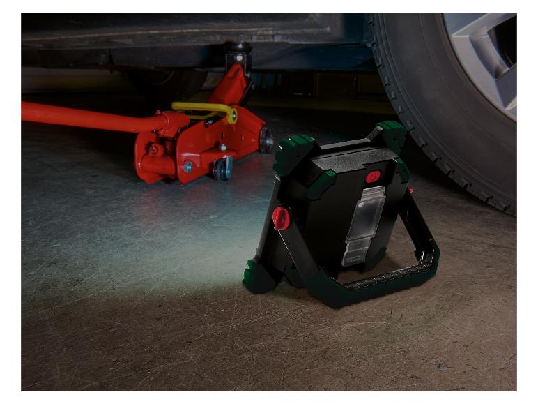 LED-Arbeitsleuchte beleuchtet ein aufgebocktes Auto und einen Hydraulikwagenheber.