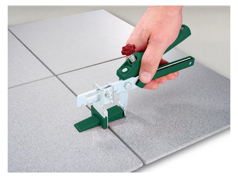 Eine grüne Fliesenzange zum Verlegen von Fliesen auf einer ebenen Fläche.