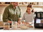 Lächelnder Vater und Tochter bereiten Gebäck mit einer smarten Küchenmaschine zu.