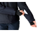 Person in dunkelblauer Jacke und Handschuhen nimmt eine weiße Karte aus der Ärmeltasche.