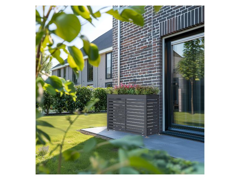 Graue Klimaanlagenabdeckung mit integriertem Pflanzgefäß auf einer modernen Terrasse.