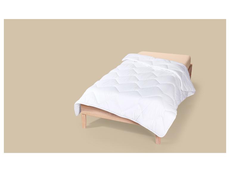LIVARNO® Bettdecke kochfest warm, 135 x 200 cm auf einem Holzbett.
