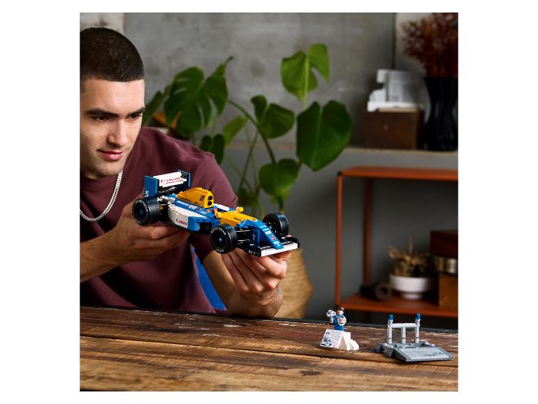Mann hält ein blau-gelbes Lego-Rennauto mit Canon- und Goodyear-Branding.