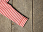 Ein rosafarbenes, gestreiftes Kleidungsstück auf einem hölzernen Hintergrund.