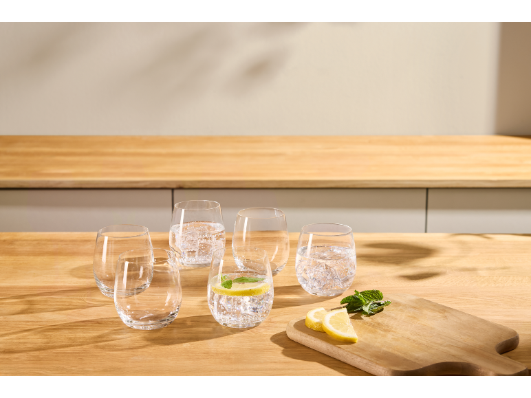 Gläser Wasser mit Zitrone und Minze auf einer Holzküchenarbeitsplatte.