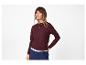 Frau in bordeauxrotem Pullover, marineblauer Hose und goldener Halskette