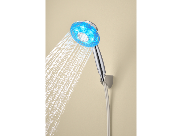 Handbrause mit blauen LED-Lichtern und Wasserstrahl, an einer beigen Wand montiert.