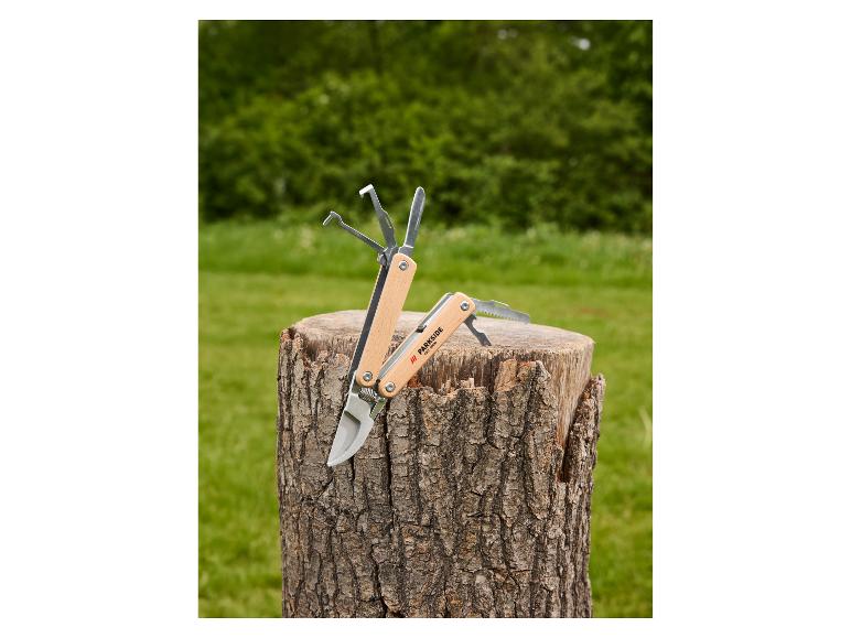 Multifunktionswerkzeug mit Holzgriff und verschiedenen Werkzeugen auf einem Baumstamm.