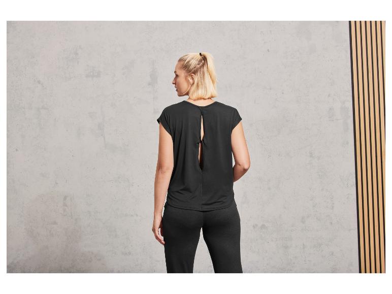 Frau in schwarzem Oberteil und Hose.