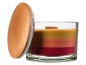 Mehrfarbige Duftkerze im Glas mit Holzdeckel.