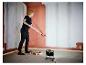 Frau streicht Wand, beleuchtet von LIVARNO® Arbeitsleuchte „The Painter+“.