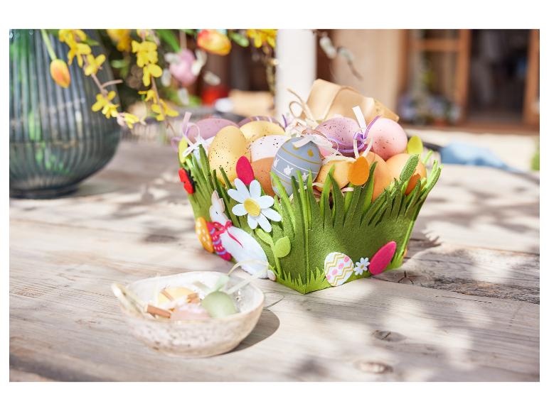 Ein Osterkorb gefüllt mit Eiern und mit Ostermotiven verziert.