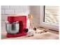 Rote SilverCrest Küchenmaschine mit Edelstahlschüssel und Backzutaten auf einer Holztheke.