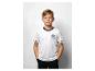 Ein Junge in einem weißen T-Shirt mit Adler-Logo und dunklen Shorts, posiert mit Händen in den Taschen.