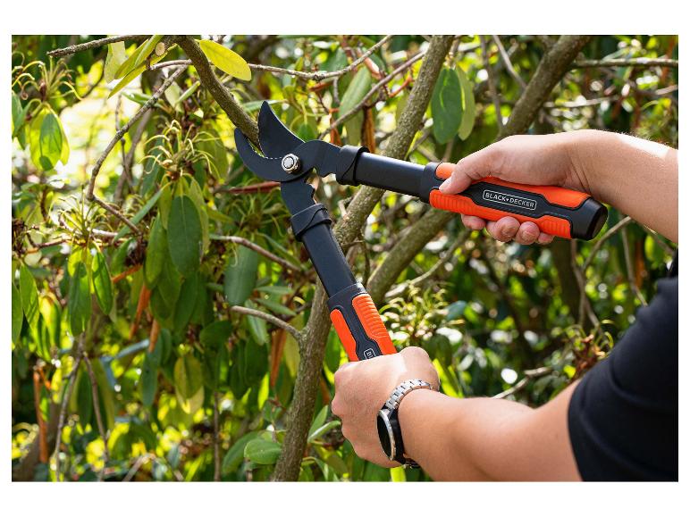 Person schneidet Ast mit Gartenschere mit orangefarbenen Griffen.