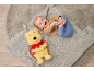 Glückliches Baby liegt auf einer Decke mit einem Teddybär.