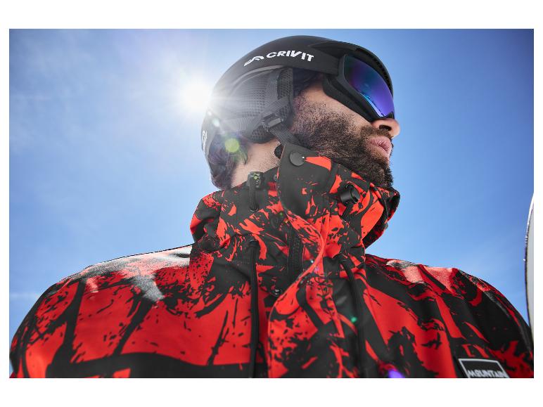 Mann mit Crivit Skihelm und Skibrille, trägt eine rot-schwarze Jacke.