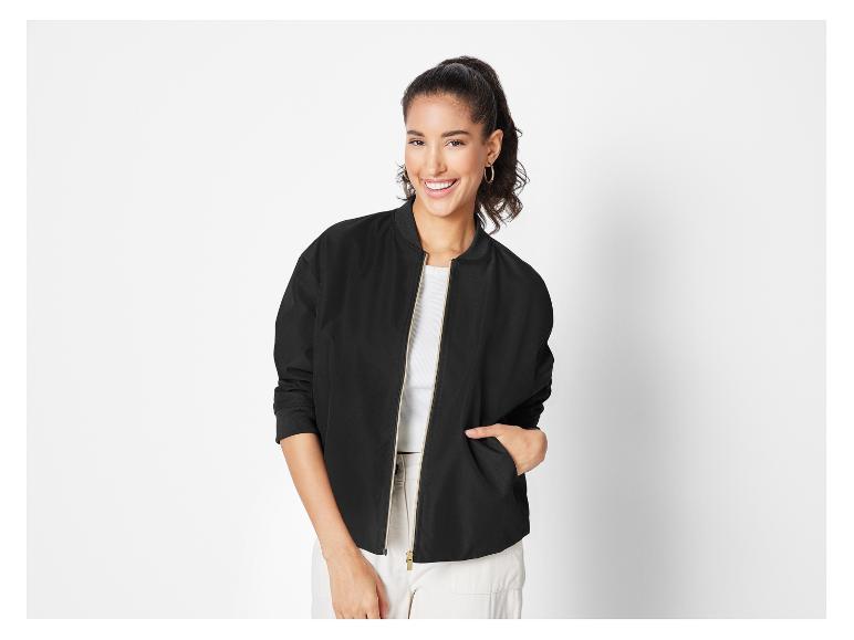 Eine Frau trägt eine schwarze Bomberjacke.