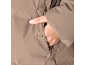 Nahaufnahme einer Frauenhand in der Tasche einer braunen Jacke.