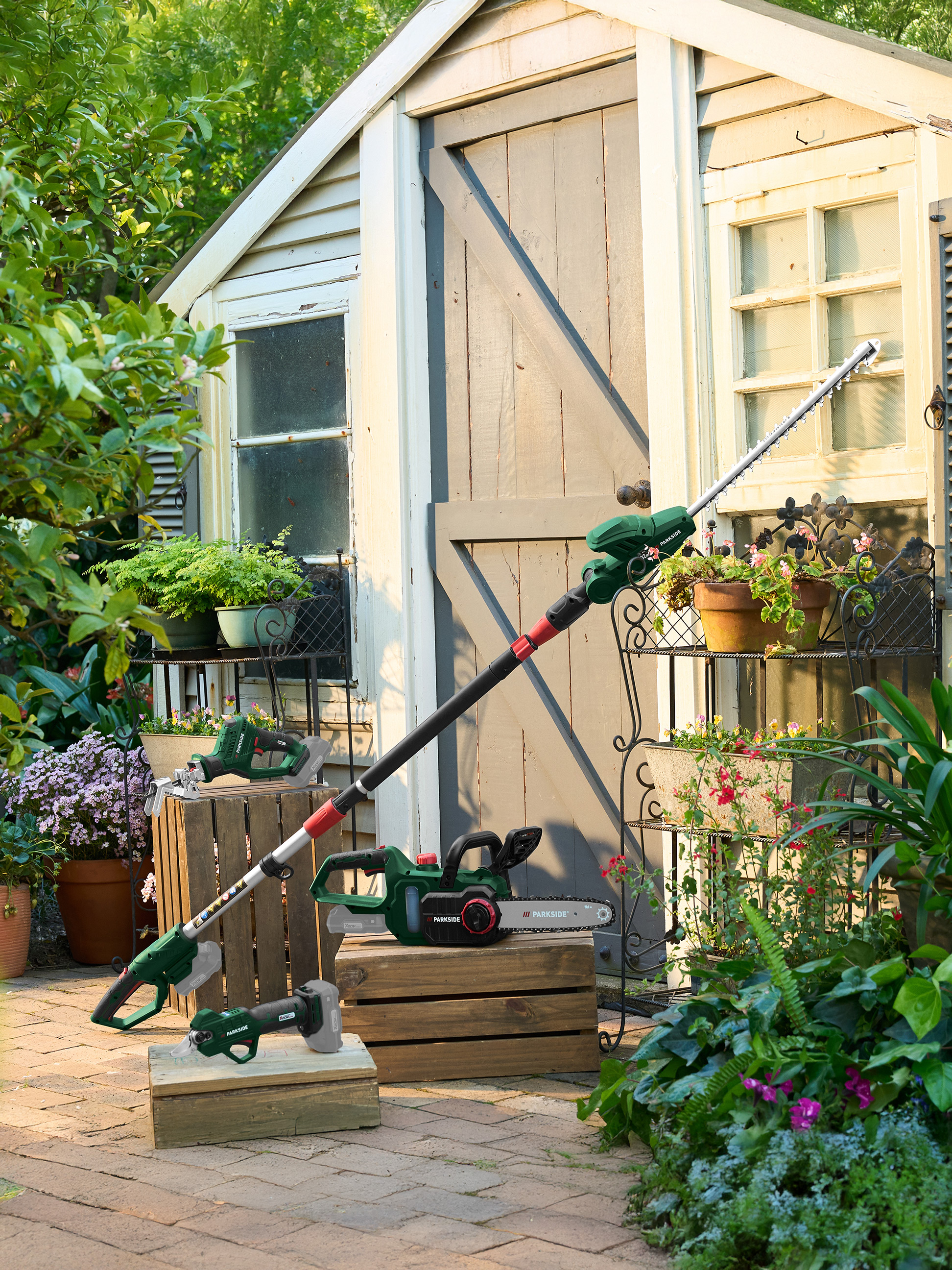 Parkside Gartengeräte: Teleskop-Heckenschere, Kettensäge und Astschere in einer Gartenumgebung.