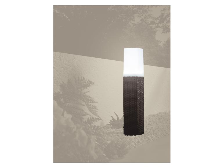 Geflochtene Säulen-Gartenlampe, die einen Kiesweg beleuchtet.