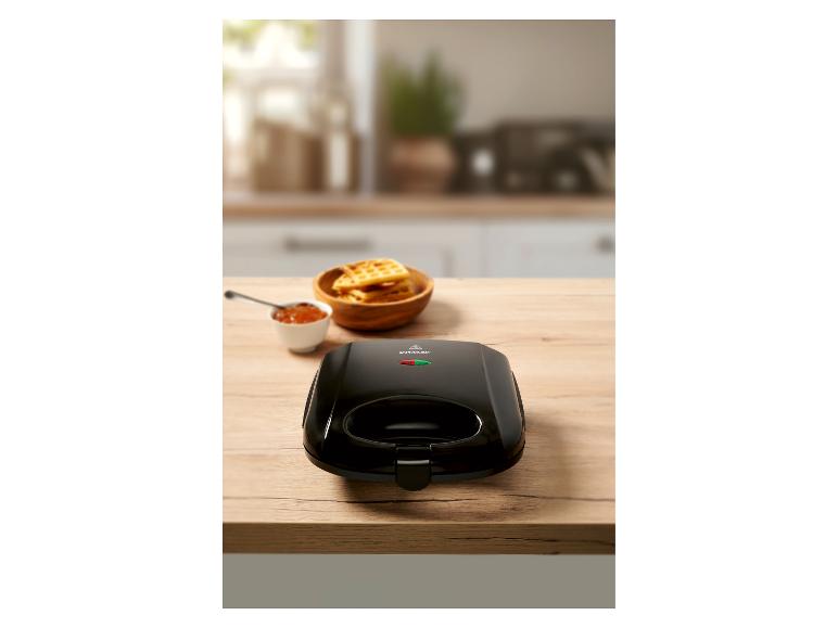 Schwarzer SilverCrest Waffeleisen und Waffeln auf einer Küchenarbeitsplatte.