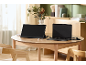 Ein tragbarer Monitor und ein Laptop, die auf einem Holztisch in einem hellen Raum angeschlossen sind.