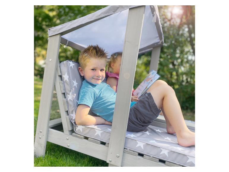 Zwei Kinder entspannen sich in einer grauen Holzschaukel mit Sternenkissen.