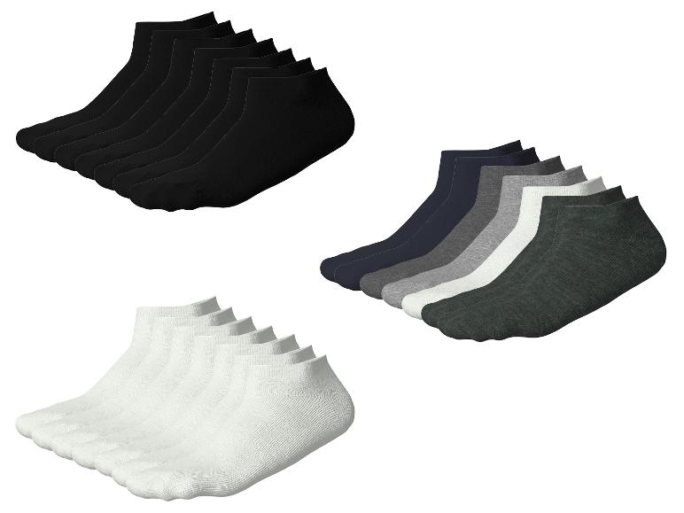 Drei Packungen Socken: schwarz, weiß und in Grautönen.