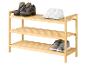 Schuhregal aus Holz mit Wanderschuhen, weißen Turnschuhen und grauen Kinderschuhen.