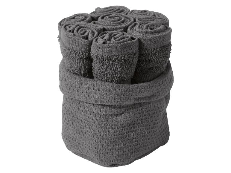 Ein Stapel grauer Handtücher in einem grauen Korb.
